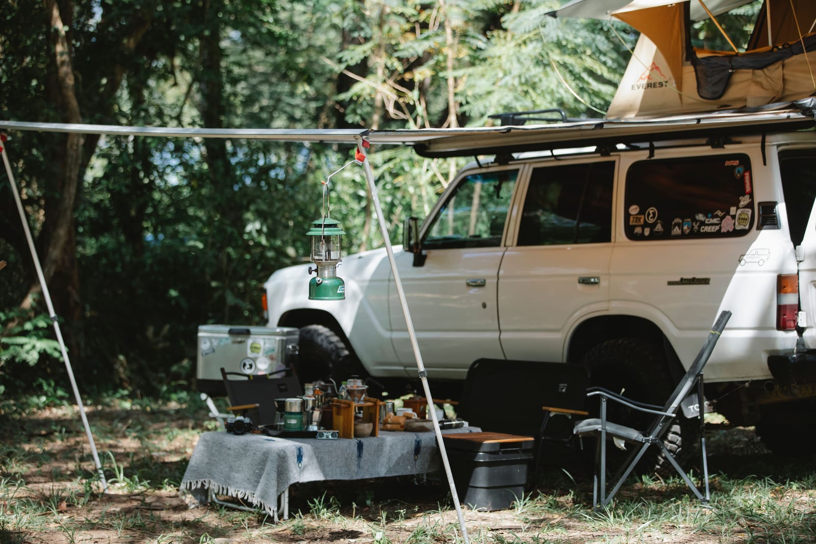 An overland camp kitchen set up beside a trailer.